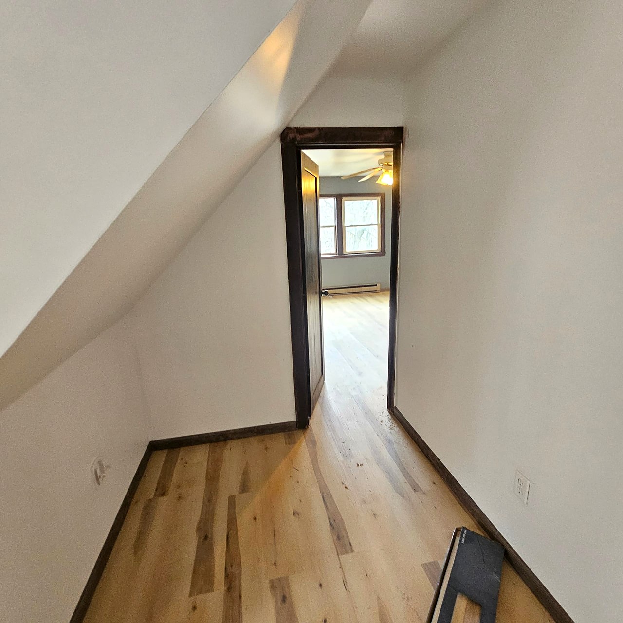 Plank flooring continuing through the upstairs hall and doorway