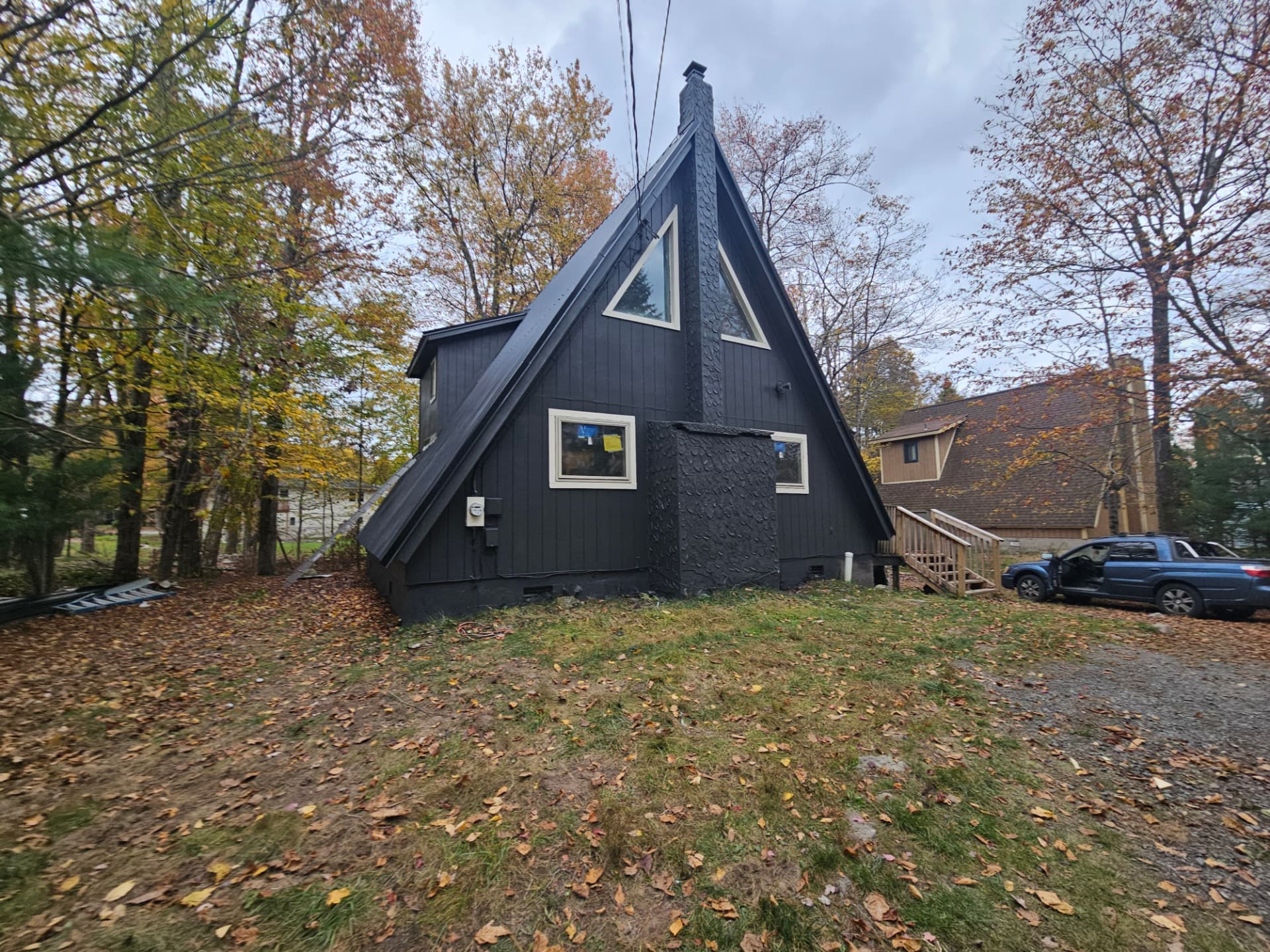 Black metal roof and fresh siding on an A-frame cabin